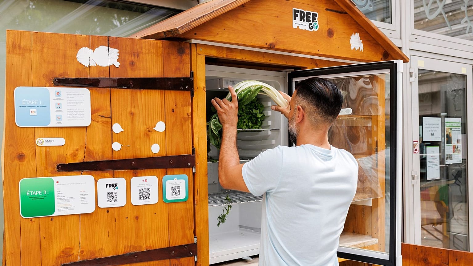 William, employee at association Eco-Citoyen, refills a public refrigerator where people can give and take food, in Geneva, Switzerland, 28 July 2023.