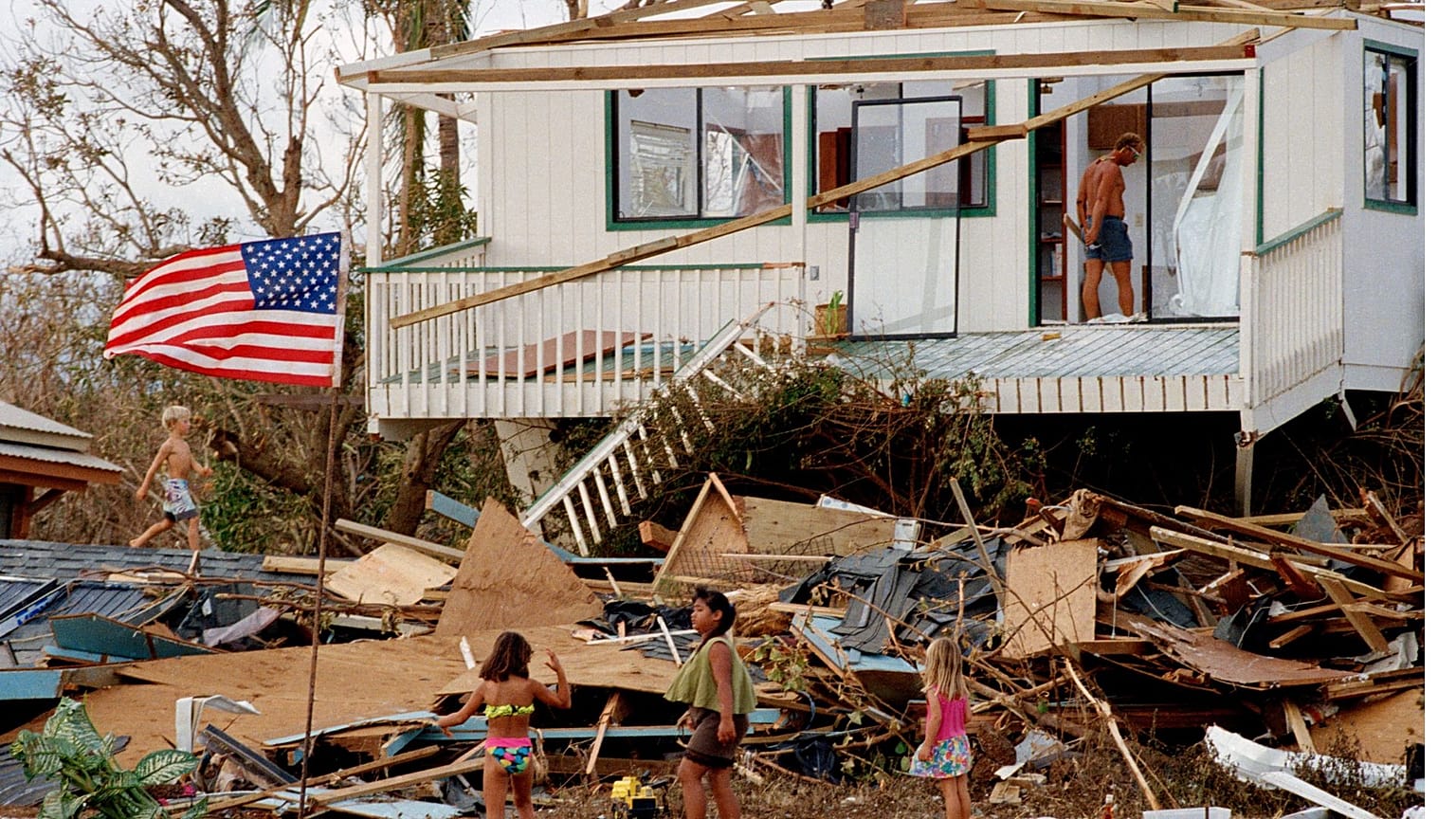 Children play in the rubble left by the fury of Hurricane Iniki, Sept. 15, 1992, at Brennecke's Beach near Poipu Beach, Hawaii, on the island of Kauai.