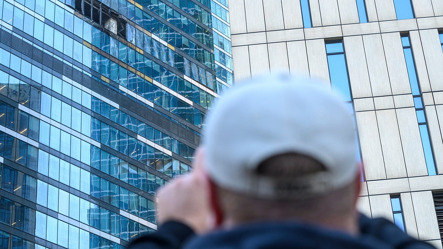Un hombre toma una foto del edificio afectado en el distrito comercial "Moscow City" tras un ataque con drones en Moscú, Rusia, el 1 de agosto de 2023.