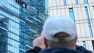 Un hombre toma una foto del edificio afectado en el distrito comercial "Moscow City" tras un ataque con drones en Moscú, Rusia, el 1 de agosto de 2023.