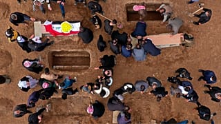 نمایی هوایی از عزاداران در حال دفن اجساد قربانیان ایزدی کشته شده توسط داعش در قبرستانی در سنجار، عراق، ۲۰۲۱