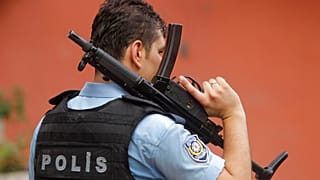 Un agente di polizia turco armato mette in sicurezza la strada che conduce all'edificio del consolato statunitense a Istanbul, lunedì 10 agosto 2015. 