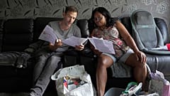 Sadie James, a la derecha, y Jon Taylor, gestor de deudas de la organización benéfica Cristianos contra la Pobreza, leen los documentos de una asociación de la vivienda en su casa, en Londres, 2023.