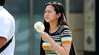 يابانية تحمل مروحة تبريد صغيرة في طوكيو [أرشيف] 