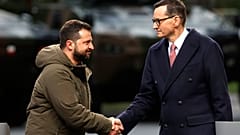 Mateusz Morawiecki lengyel miniszterelnök kezet fog Volodimir Zelenszkij ukrán elnökkel közös varsói sajtótájékoztatójukon. 2023. április 5-én