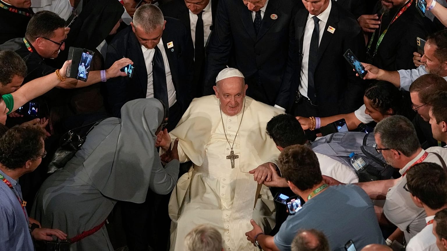 A nun kisses the hand of Pope Francis las he eaves the Jeronimos Monastery after Vespers in Lisbon, Wednesday, Aug. 2, 2023.