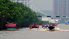 Equipas de salvamento utilizam barcos para evacuar residentes, numa cidade próxima de Pequim, na China.