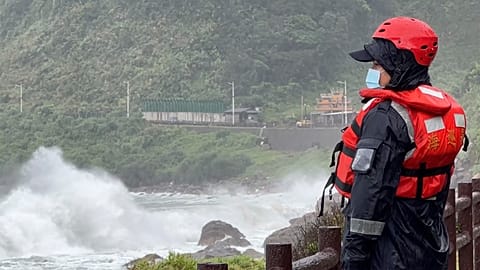 Oficial da guarda costeira observa as ondas antes da passagem do tufão Khanun, no norte de Taiwan, esta quinta-feira.