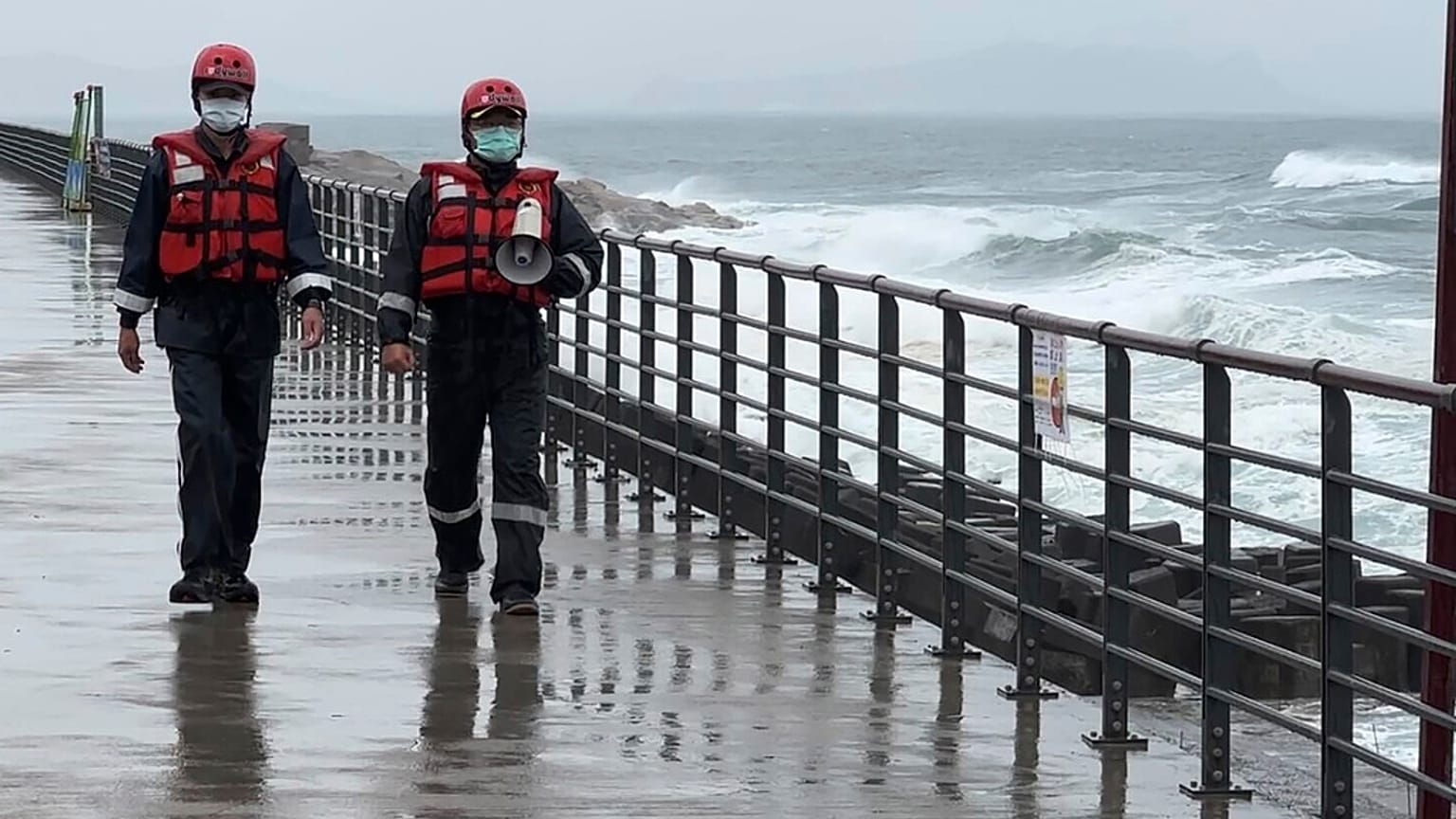 Coast guard officers patrol along the coast ahead of typhoon Khanun in the port city of Keelung near Taipei in northern Taiwan on Thursday, Aug. 3, 2023.