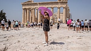 Szelfiző turista az Akropolisz-hegy tetején álló Parthenon templom előtt Athénban, Görögországban, 2023. július 21-én