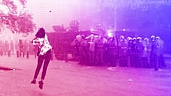 An anti-government protester woman throws a stone towards riot police during a protest near Parliament Square, in Beirut, September 2020