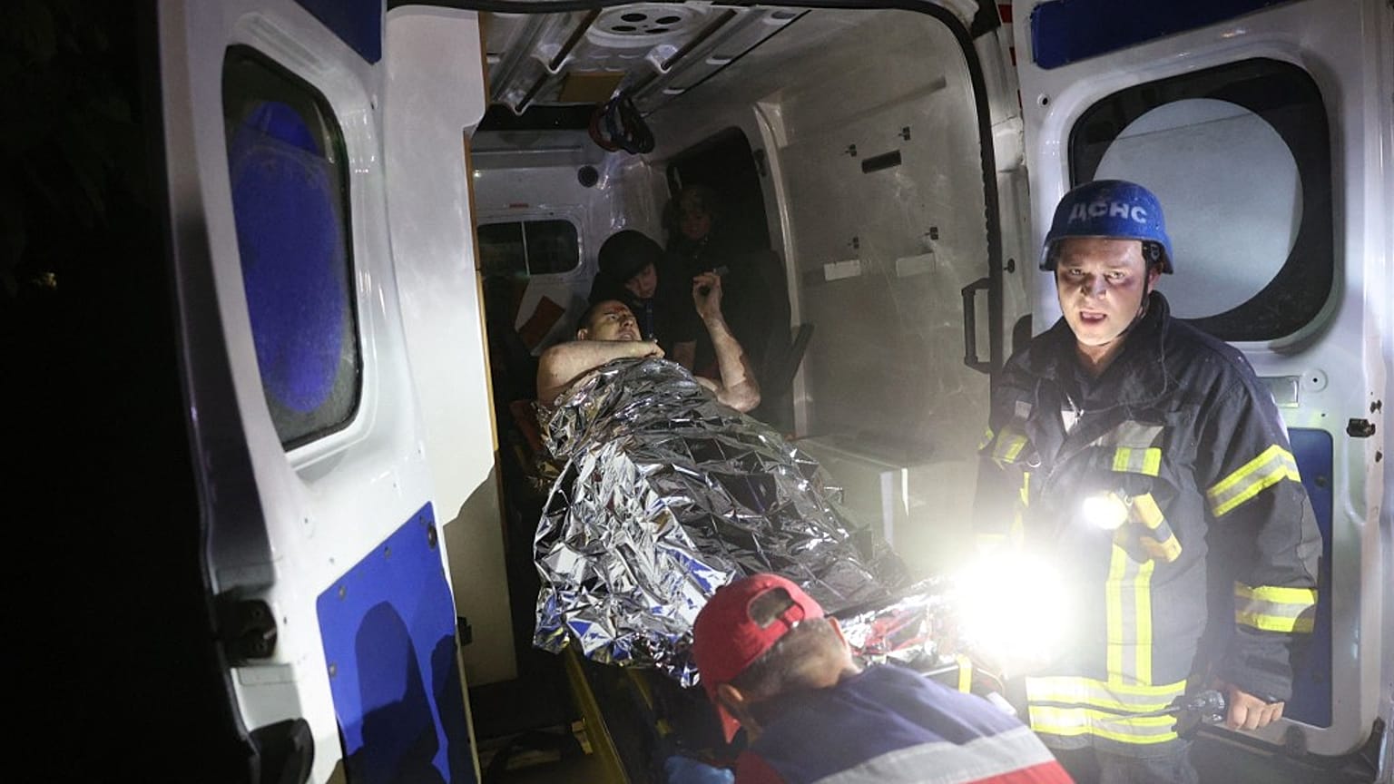 Socorristas transportam uma pessoa ferida na sequência dos ataques a Pokrovsk para dentro de uma ambulância, Donetsk, Ucrânia
