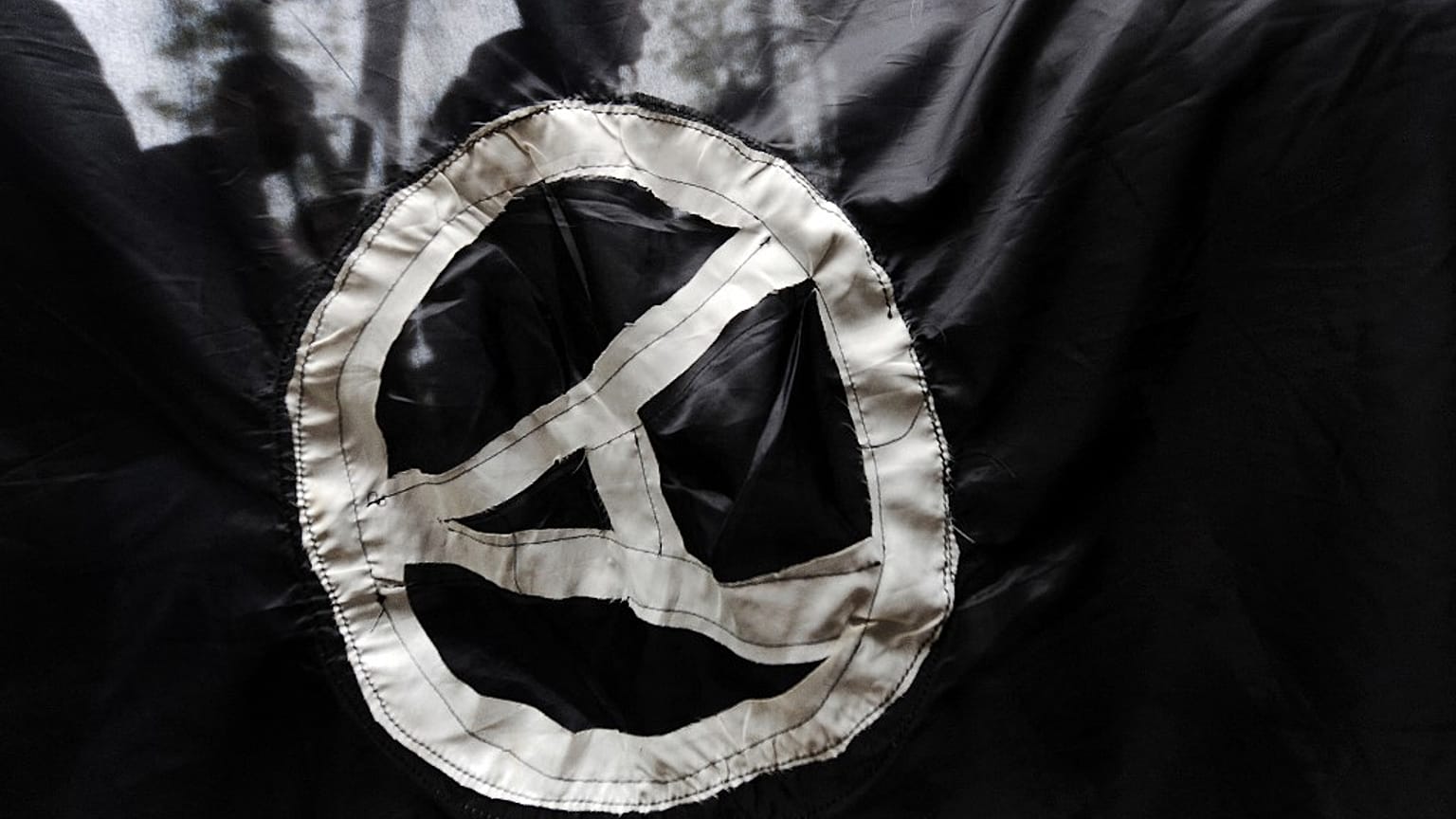 FILE - Anarchist supporters are seen through an anarchist flag during a rally marking the International May Day on May 1, 2009. 