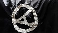FILE - Anarchist supporters are seen through an anarchist flag during a rally marking the International May Day on May 1, 2009. 