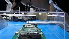 A visitor examines a computer chipset at the booth for Chinese semiconductor and chip developer Kunlunxin during the World AI Conference in Shanghai, Wednesday, July 5, 2023.