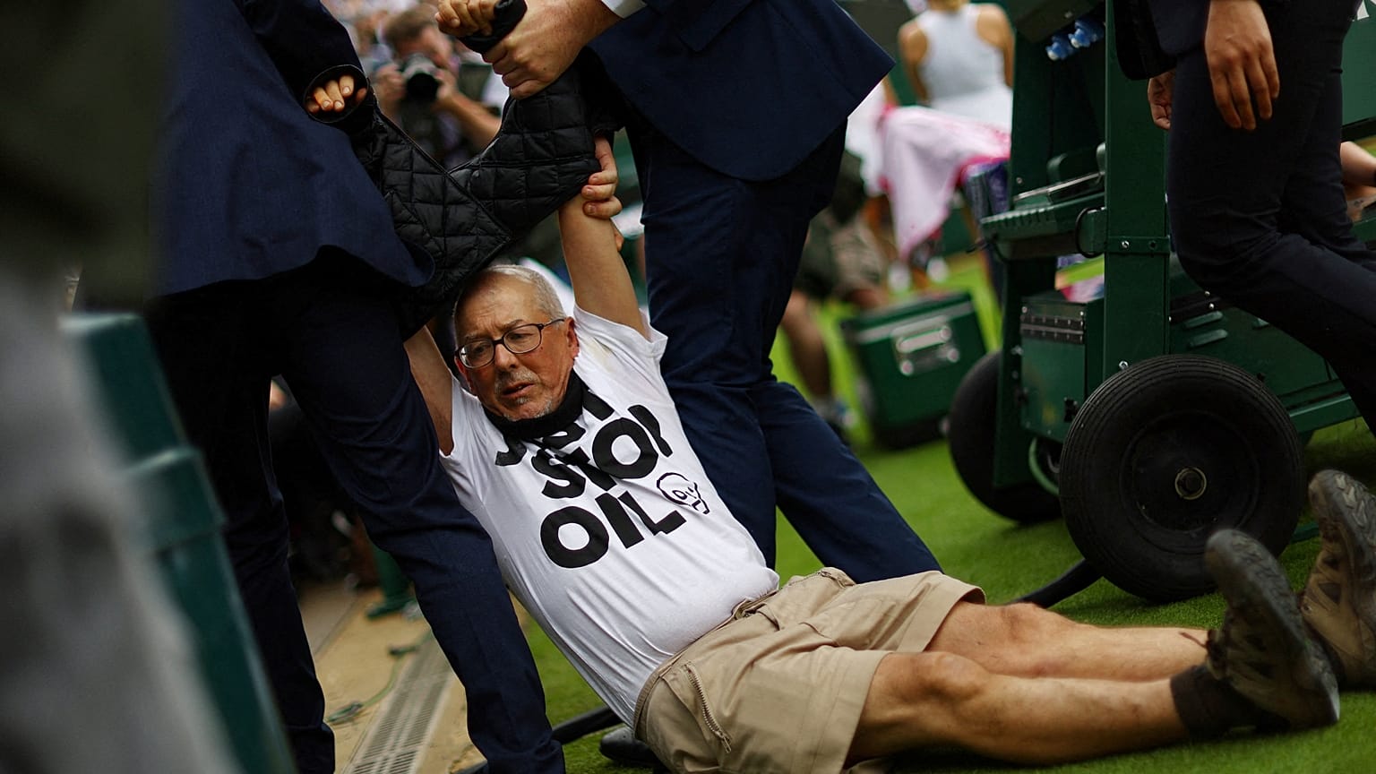 Un manifestant de Just Stop Oil est retenu par le personnel de sécurité sur le court 18 pendant Wimbledon à Londres. 