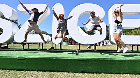 Young participants pose for photos at the logo of the "Sziget" Island Festival in the Hajogyar (Shipyard) Island of Budapest on August 10, 2023.