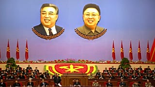 Kuzey Kore'nin eski liderleri Kim Il Sung (solda) ve Kim Jong İl'in portreleri