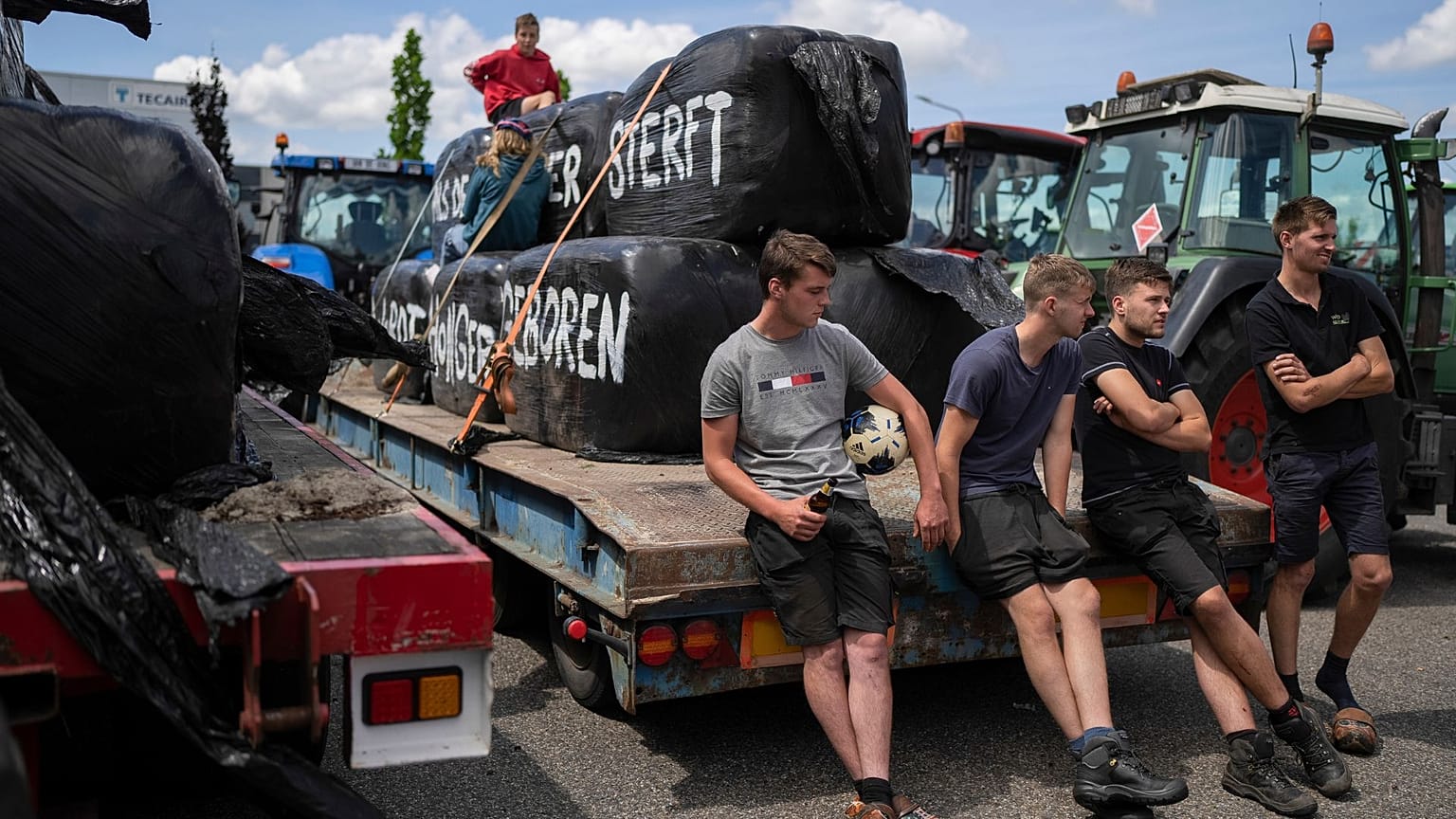 Protesting farmers talk at a blockade outside a distribution centre for supermarket chain Aldi in the town of Drachten, northern Netherlands, on 4 July 2022.