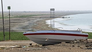 توقف قارب بسبب انحسار خط المياه في بحيرة الحبانية المتضررة من الجفاف الشديد في محافظة الأنبار العراقية، في 11 آب / أغسطس 2023.