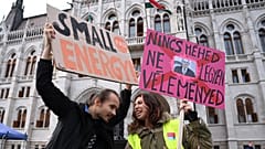 People hold up a placard reading "If you don't have the uterus, don't comment"(R) at a protest in front of the parliament building in Budapest, Hungary on September 28, 2022.