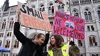People hold up a placard reading "If you don't have the uterus, don't comment"(R) at a protest in front of the parliament building in Budapest, Hungary on September 28, 2022.