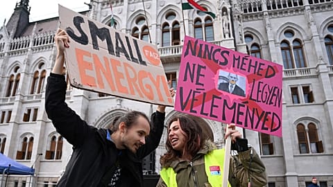 People hold up a placard reading "If you don't have the uterus, don't comment"(R) at a protest in front of the parliament building in Budapest, Hungary on September 28, 2022.