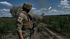 Украинский солдат наблюдает за тем, как система залпового огня "Град" выпускает снаряды с листовками в районе Бахмута, Донецкая область, Украина, воскресенье, 13 августа 2023 