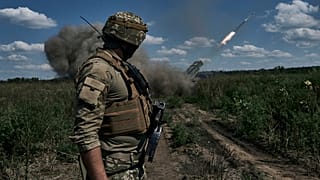 Украинский солдат наблюдает за тем, как система залпового огня "Град" выпускает снаряды с листовками в районе Бахмута, Донецкая область, Украина, воскресенье, 13 августа 2023 