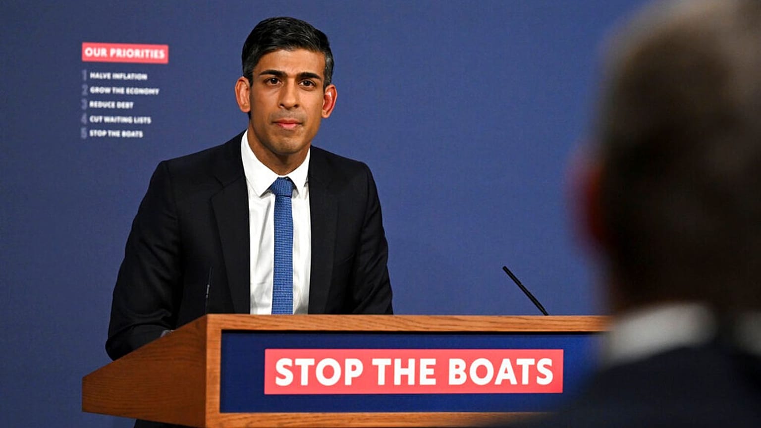 تریبون ریشی سوناک، نخست‌وزیر بریتانیا با شعار «قایق‌ها را متوقف کنید» (عکس از آرشیو)