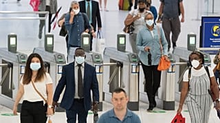 Des personnes traversent le World Trade Center, vendredi 9 juillet 2021, à New York.