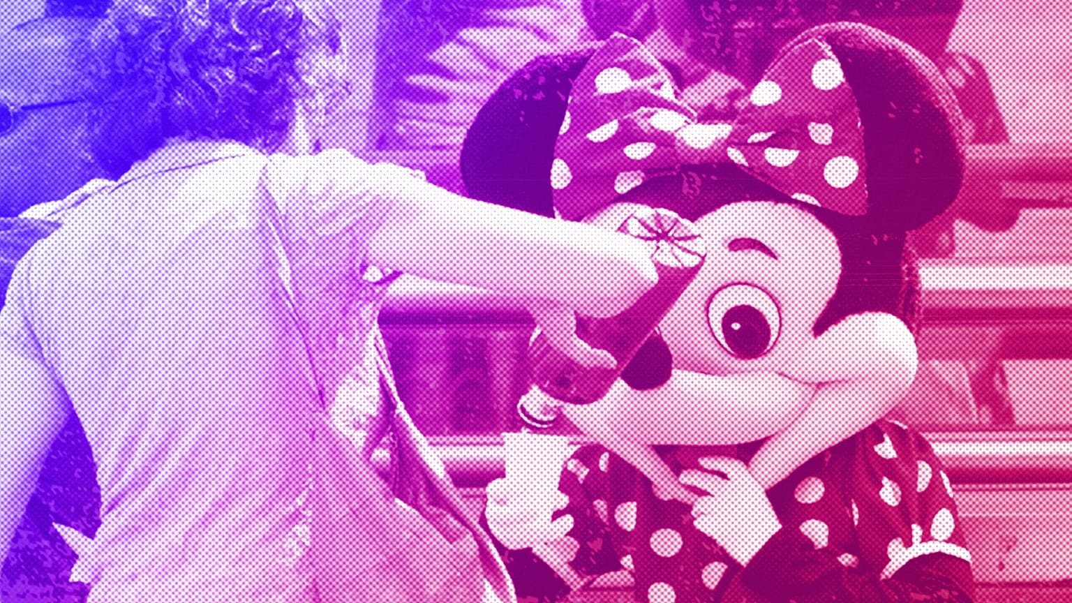 A woman stops to give water to a person dressed in a Mini Mouse costume, one of many who work posing for tourist photos in Madrid, August 2012
