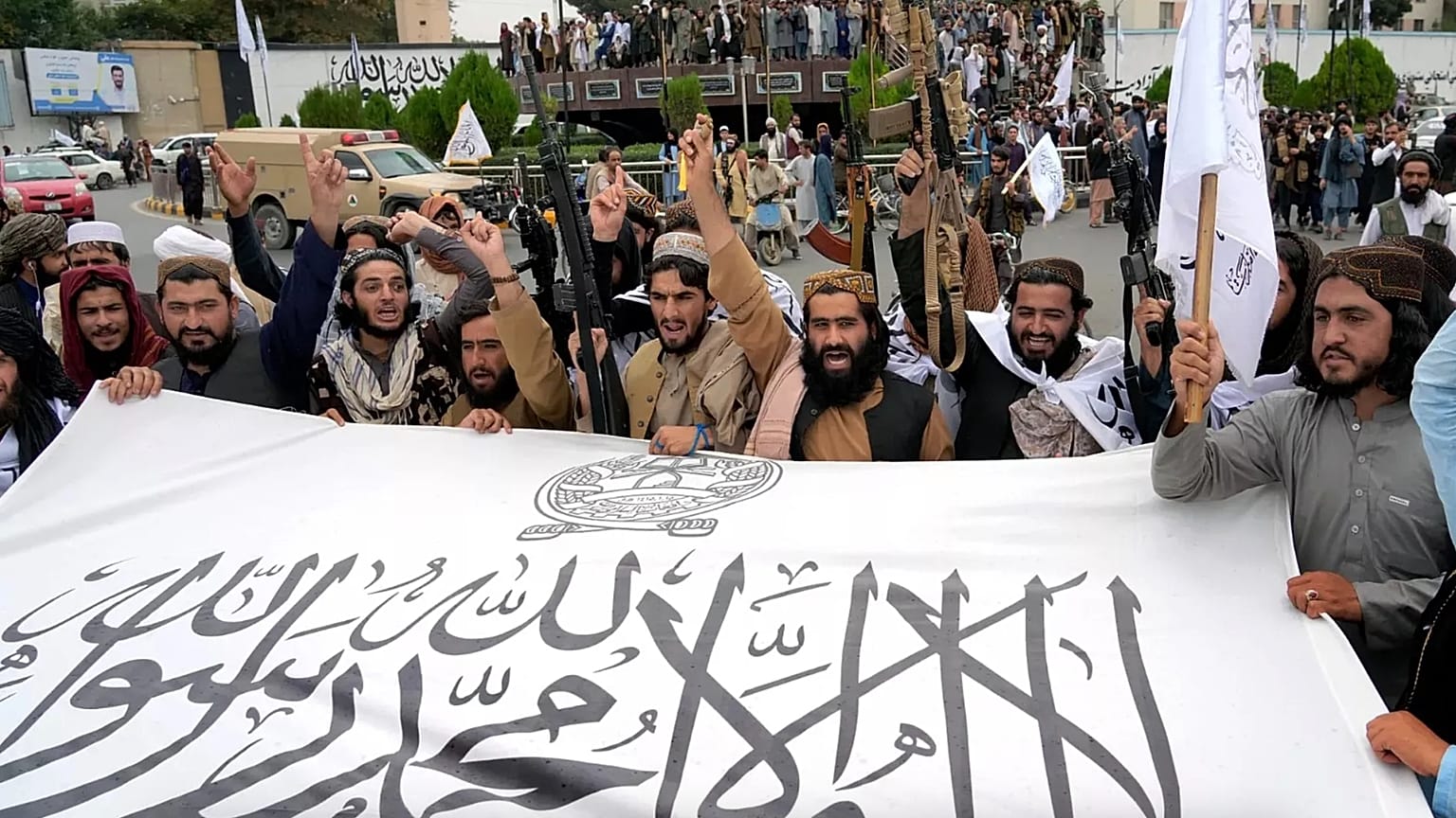 Taliban savaşçıları, Afganistan'ın başkenti Kabil'i ele geçirmelerinin birinci yılını kutlarken bayraklarını tutuyorlar, 15 Ağustos, 2022.