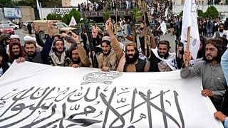 Taliban savaşçıları, Afganistan'ın başkenti Kabil'i ele geçirmelerinin birinci yılını kutlarken bayraklarını tutuyorlar, 15 Ağustos, 2022.
