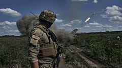 Ukrán katona egy Grad rakétát néz Bahmutnál 