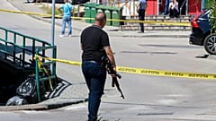 Ein Polizist hält ein Gewehr während einer großen Verfolgungsjagd nach einem Mann, der seinen Partner erschossen hat, während er dies live auf Instagram in Gradacac, Bosnien, sendet. 11\. August 2023