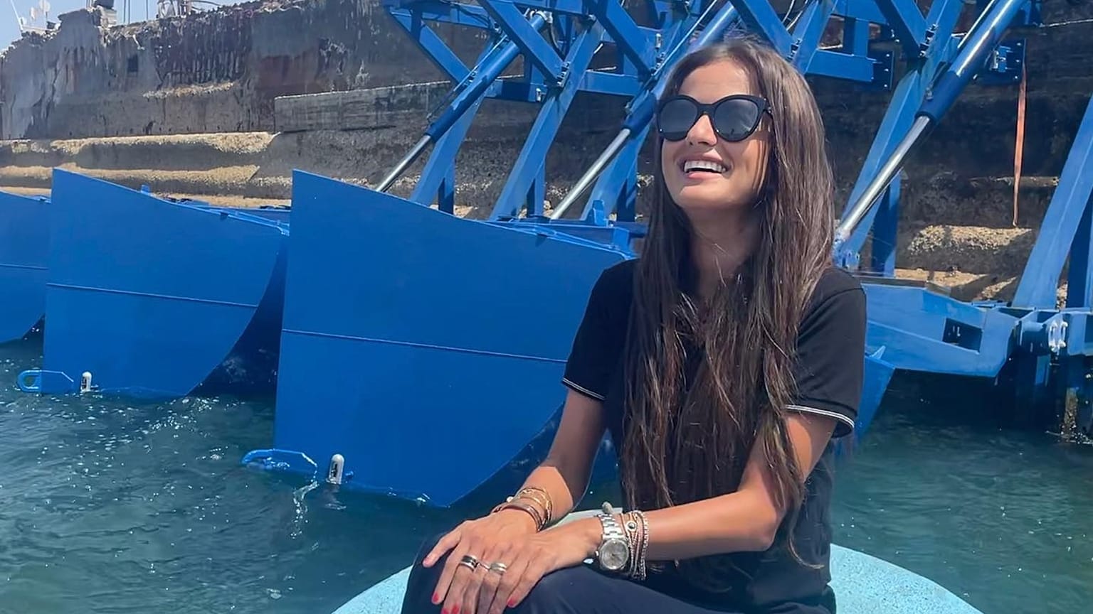 Inna Braverman sits infront of the Eco Wave Power station installed in Israel. 