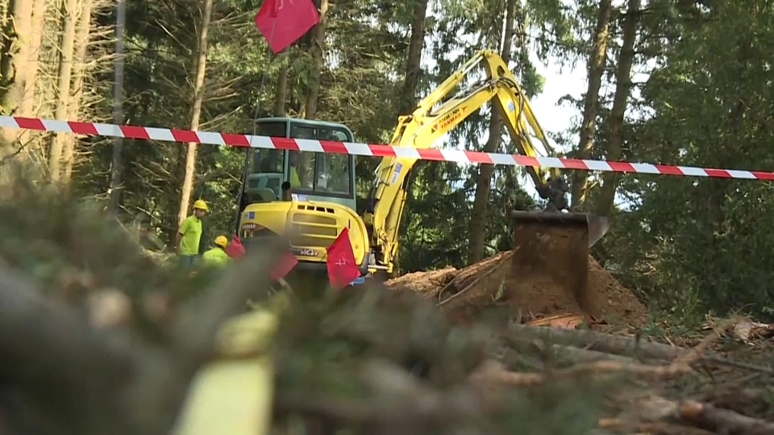 Mit schwerem Gerät wird nach den Überresten der Erschossenen gegraben.