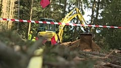 Mit schwerem Gerät wird nach den Überresten der Erschossenen gegraben.