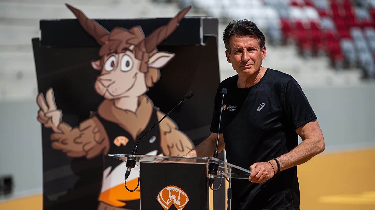 Sebastian Coe (mögötte a vb kabalafigurája) beszél a budapesti Nemzeti Atlétikai Központban 2023. június 15-én. 