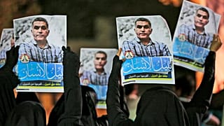 متظاهرون بحرينيون مناهضون للحكومة يرفعون صورًا لناشط حقوق الإنسان المسجون نبيل رجب خلال احتجاج تضامني في البحرين
