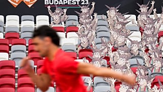 A világbajnokság kabalaállata, Youhuu a lelátón, az előtérben egy futóval