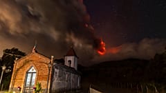 Smoke billows from Mount Etna volcano, as seen from the Magazzeni church near the village of Sant'Alfio, north of Catania, Sicily, 12 November 2023.