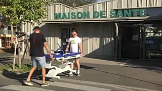 Vizsgálóágyat visznek ki a háziorvosi rendelő épületéből Mulhouse-ban, 2023. augusztus 18-án