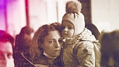 A woman holds her daughter as they try to get on a train at the Kyiv station, 4 March 2022