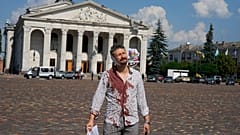 Verletzer Mann vor dem zerstörten Theater in Tschernihiw in der Ukraine