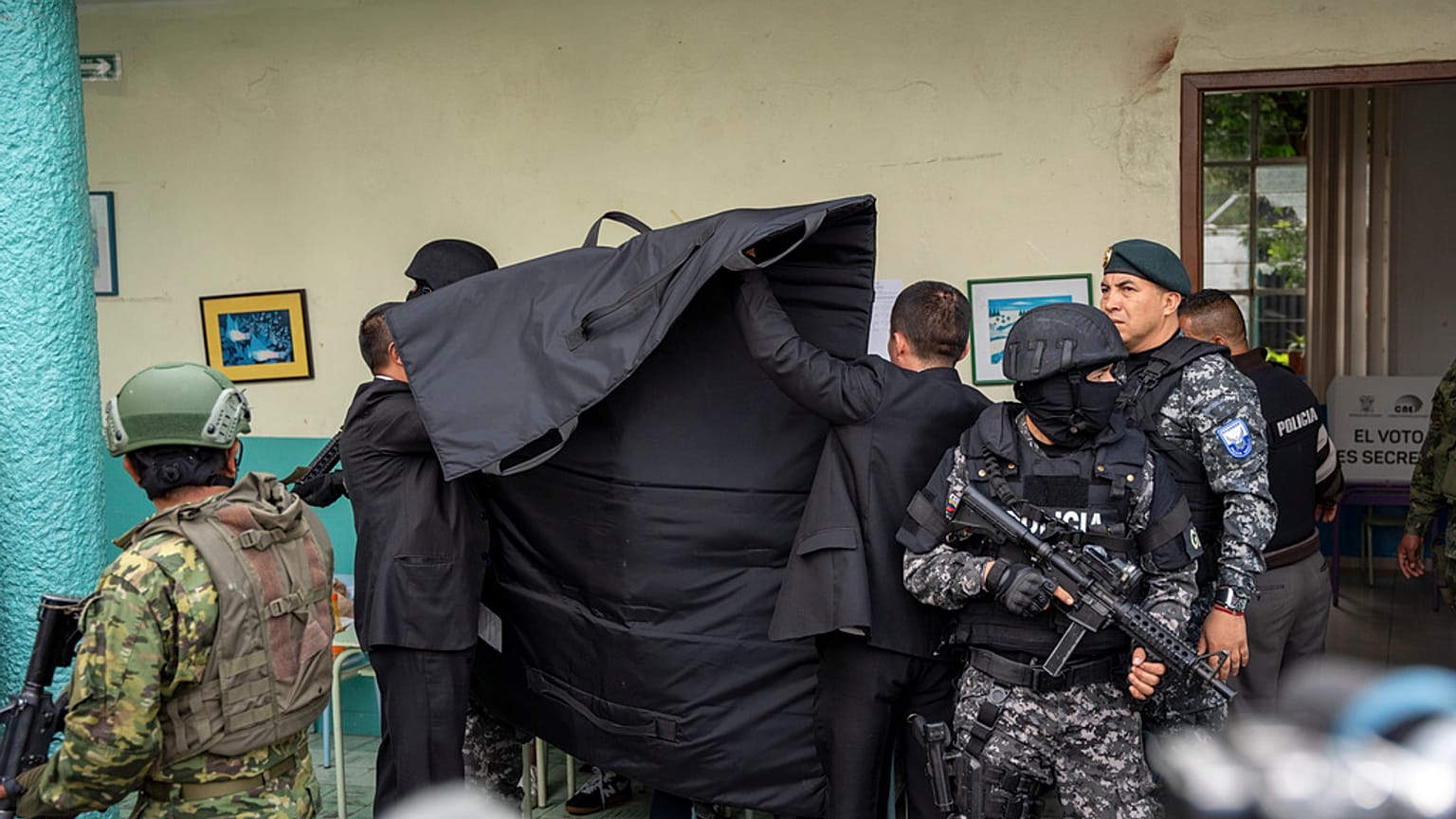 La policía cubre al candidato presidencial Christian Zurita, del "Movimiento Construye", mientras marca su papeleta en unas elecciones anticipadas en Quito, Ecuador