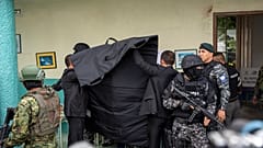 La policía cubre al candidato presidencial Christian Zurita, del "Movimiento Construye", mientras marca su papeleta en unas elecciones anticipadas en Quito, Ecuador
