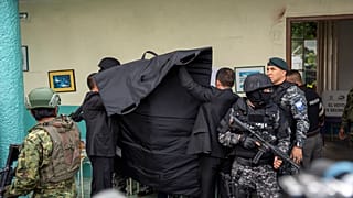 La policía cubre al candidato presidencial Christian Zurita, del "Movimiento Construye", mientras marca su papeleta en unas elecciones anticipadas en Quito, Ecuador