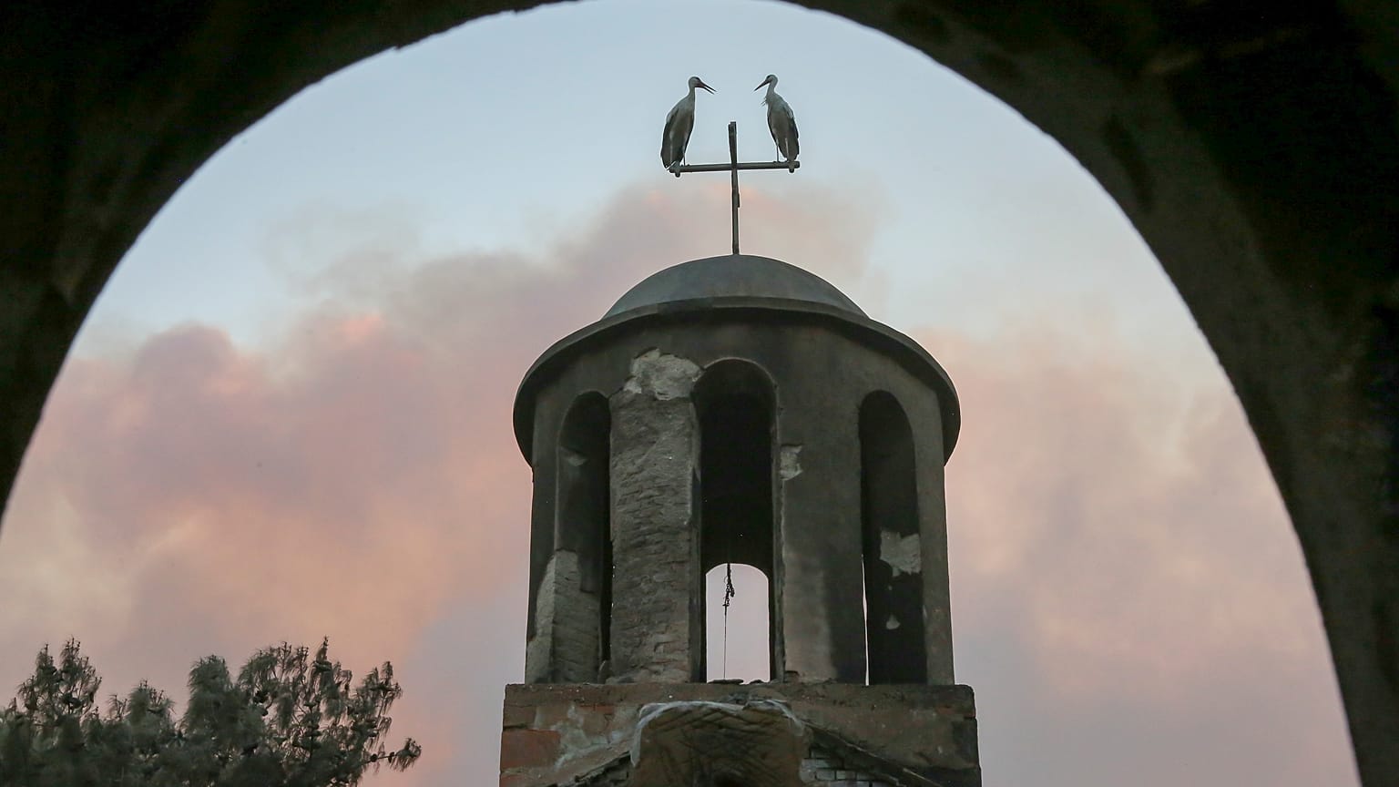 Zwei Störche sitzen auf dem Turm einer ausgebrannten Kirche neben Alexandroupolis